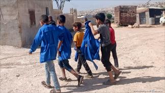 أطفال عائدون من مدارسهم في مخيمات دير حسان (العربي الجديد)