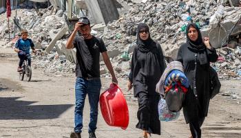 فلسطينيون يحملون أغراضهم في حي الزيتون وسط قطاع غزة هرباً من القصف الإسرائيلي 9/5/2024 (فرانس برس)