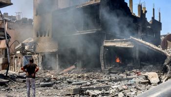 فلسطيني ينظر إلى بناء يحترق في حي الزيتون وسط قطاع غزة بسبب القصف الإسرائيلي 9/5/2024 (فرانس برس)