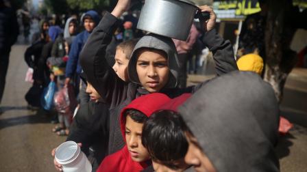 أطفال نازحون ينتظرون الحصول على الطعام في مخيم للاجئين وسط غزة، 2 فبراير 2024 (Getty)