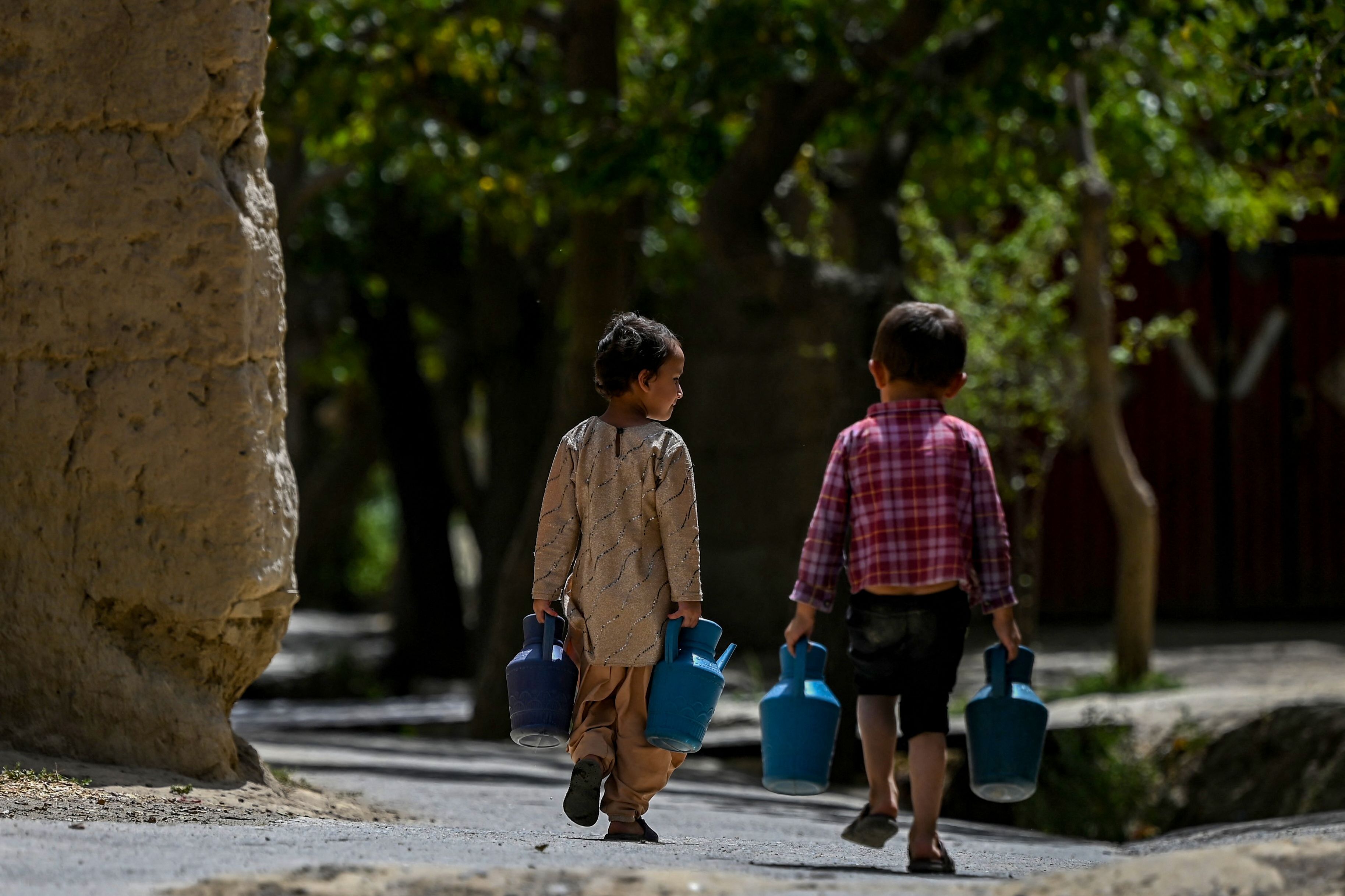 صغيران ينقلان المياه في باروان (وكيل كوشار/ فرانس برس) 