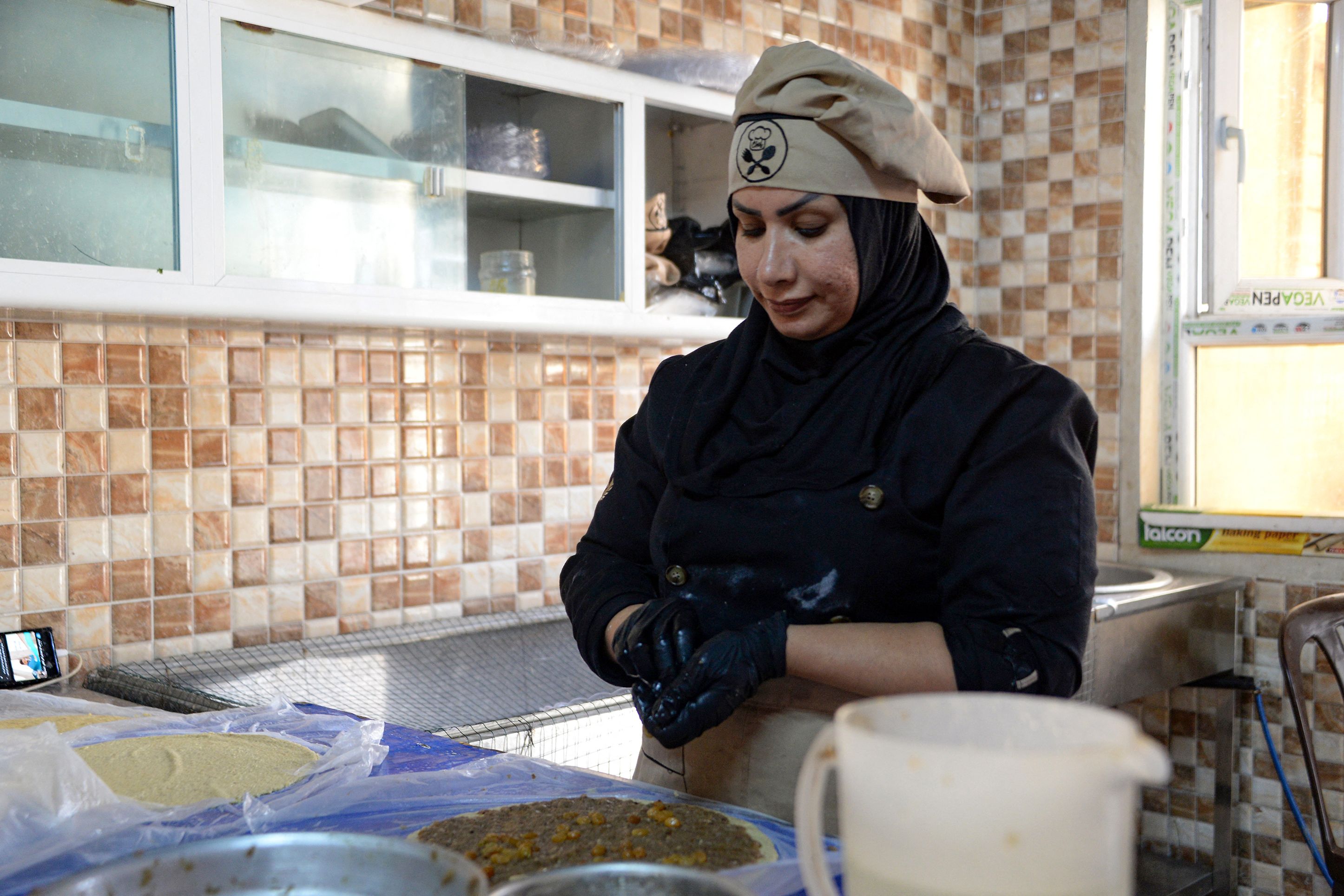 يشجع عراقيون النساء على صنع الأطعمة وبيعها لجني الرزق (زيد العبيدي/ فرانس برس)