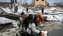 أوكرانيون يهربون من الحرب في أوكرانيا (أريس ميسينيس/ فرانس برس)