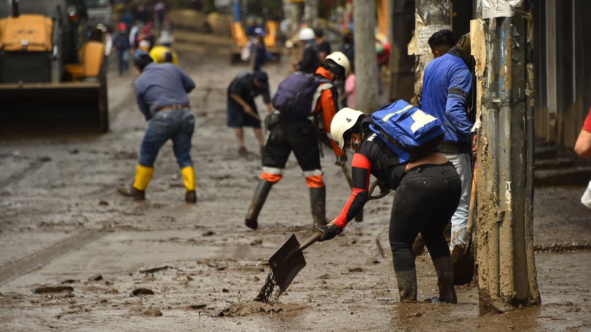 يعملون على إزالة الوحول في الإكوادور (رودريغو بوينديا/ فرانس برس)