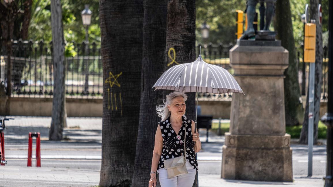 تحمي نفسها من الشمس في برشلونة الإسبانية (باكو فرير/ Getty)