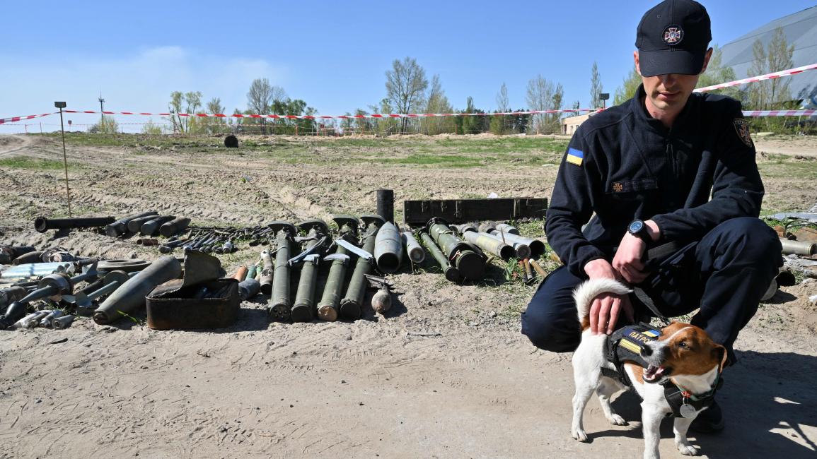  مع كلب صغير ساهم في نزع مخلفات أسلحة قرب مطار كييف (سيرغي سوبينسكي/ فرانس برس)