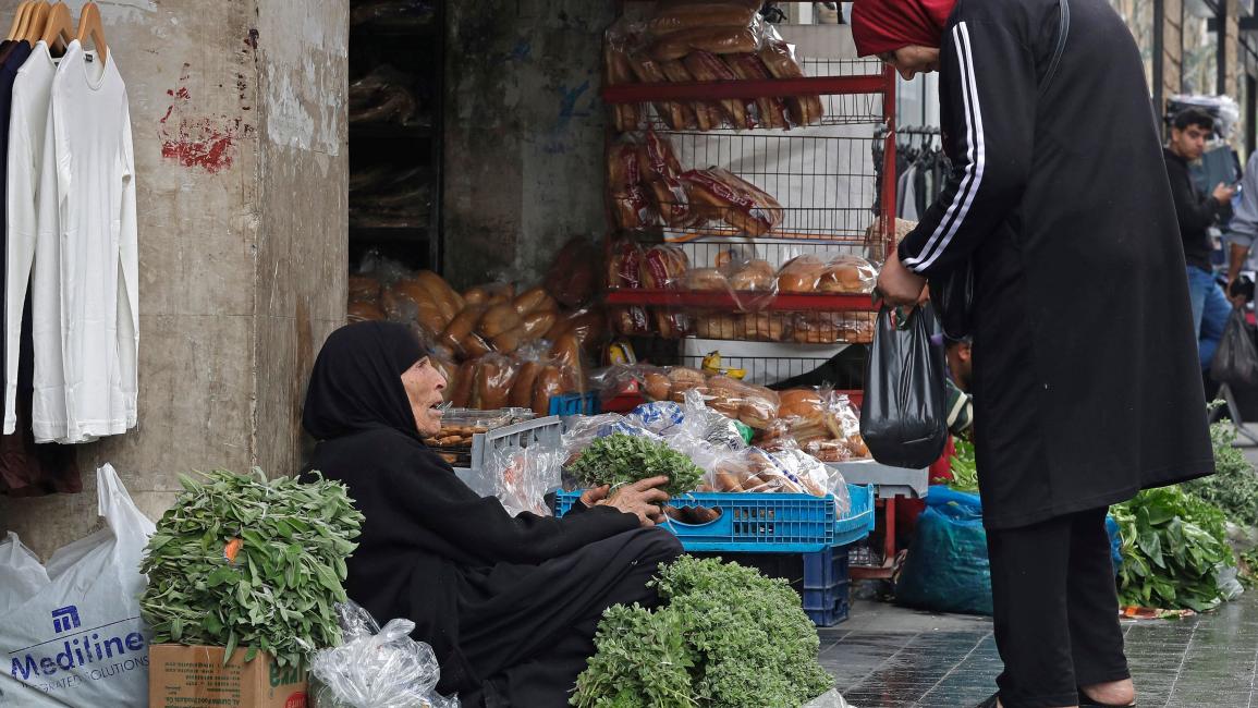 تشتري أعشاباً من بائعة فقيرة في لبنان (محمود زيات/ فرانس برس)