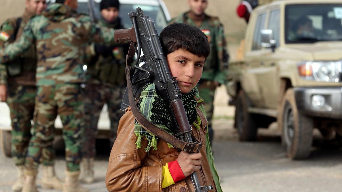 طفل عراقي يحمل سلاحاً عسكرياً (إمره يلماز/الأناضول)
