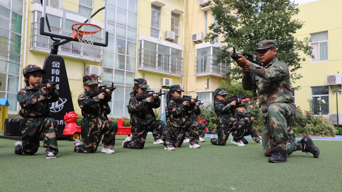 أطفال صينيون يتدربون على حمل السلاح (Getty)