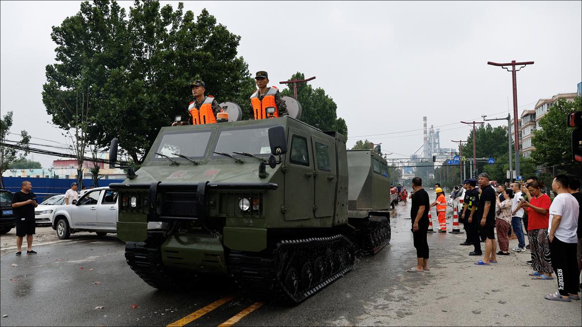 سيارة شبه عسكرية تابعة للشرطة تقلّ سكاناً تقطعت بهم السبل (رويترز/تينغشو وانغ)
