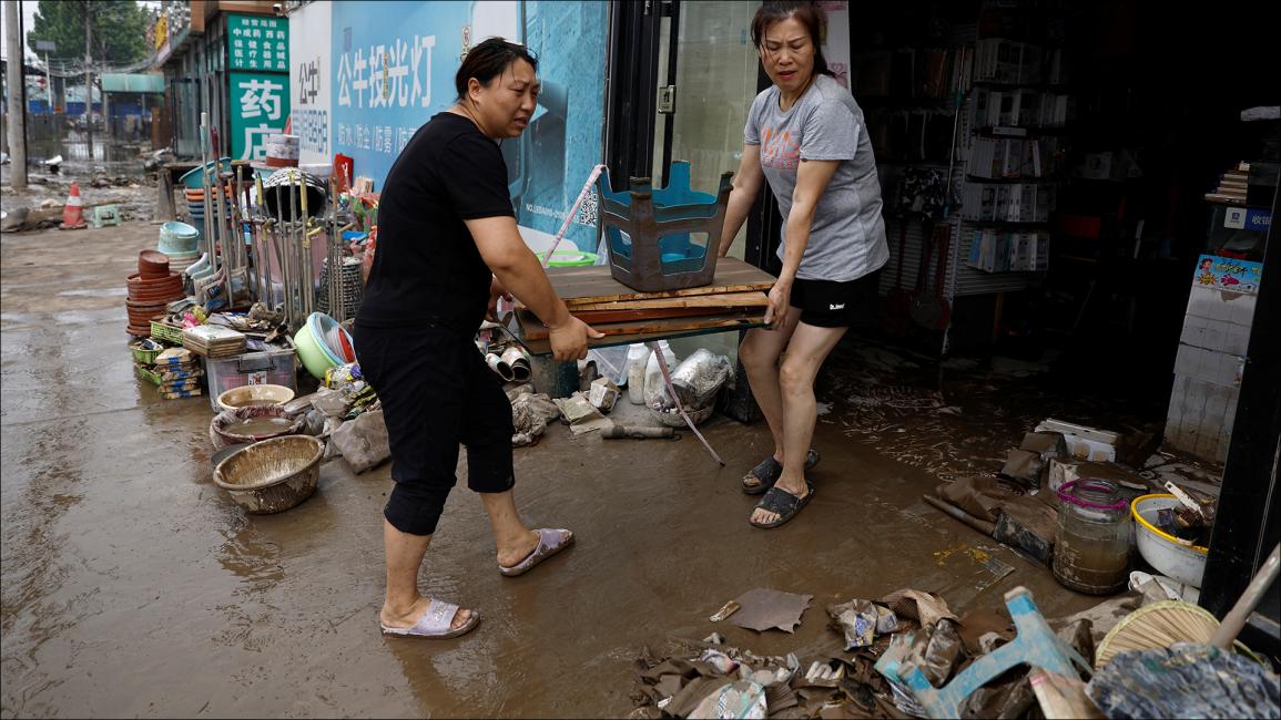 محاولة أصحاب المتاجر إنقاذ البضائع (رويترز/تينغشو وانغ)