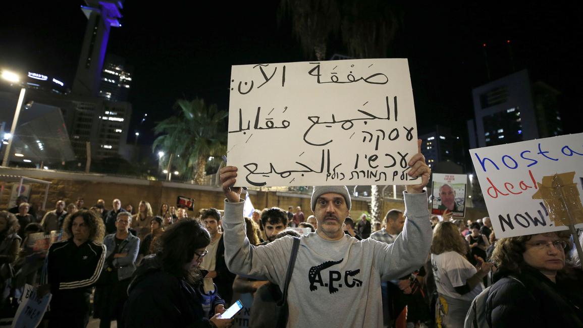 مستوطن يحمل لافتة باللغة العربية يطالب بصفقة فورية وتبادل جميع الأسرى مقابل جميع المحتجزين (أليكسي ج. روزنفيلد/ Getty)