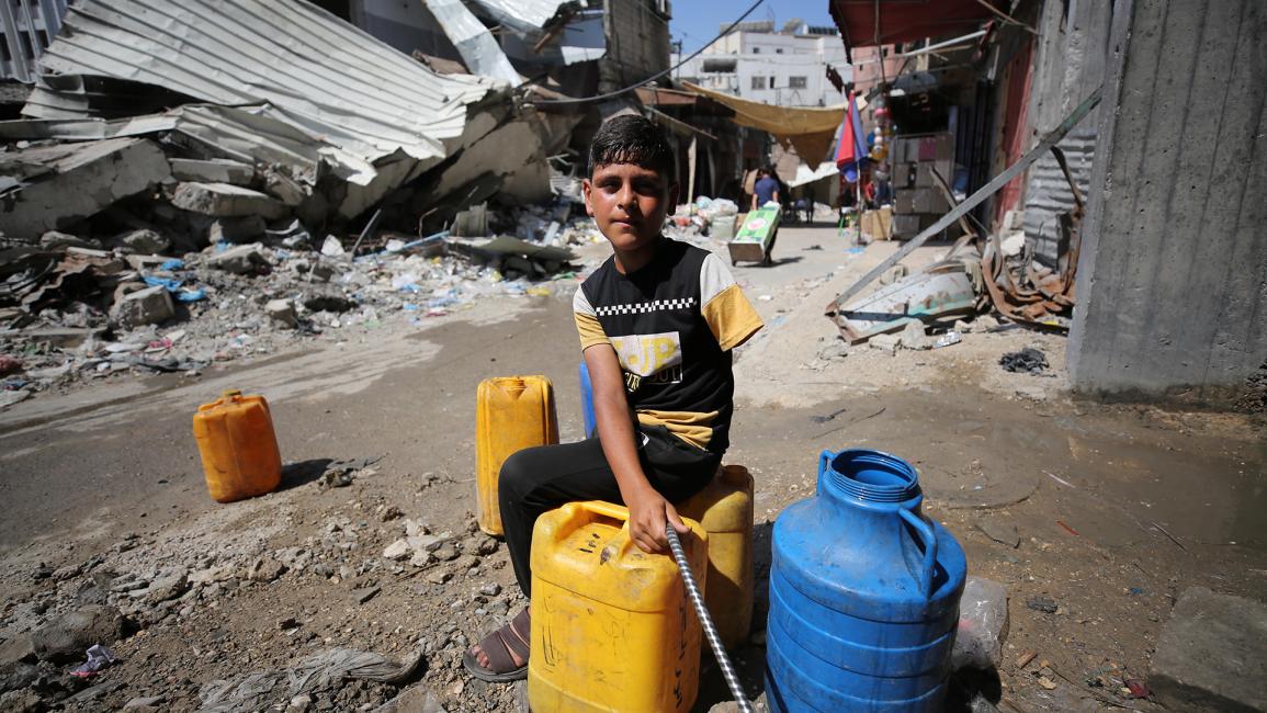 طفل فلسطيني خسر ذراعه يبحث عن الماء (داود أبو الكاس/الأناضول)