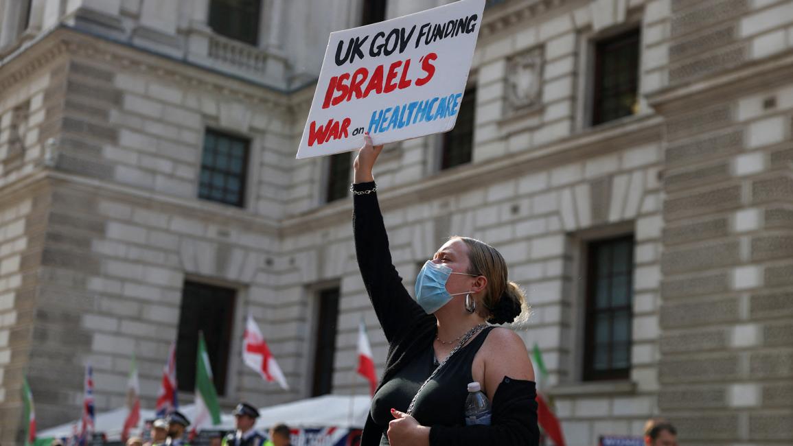 متظاهرة بريطانية تتهم بلادها بالتواطؤ مع إسرائيل على حساب البريطانيين (رويترز / هولي آدامز)