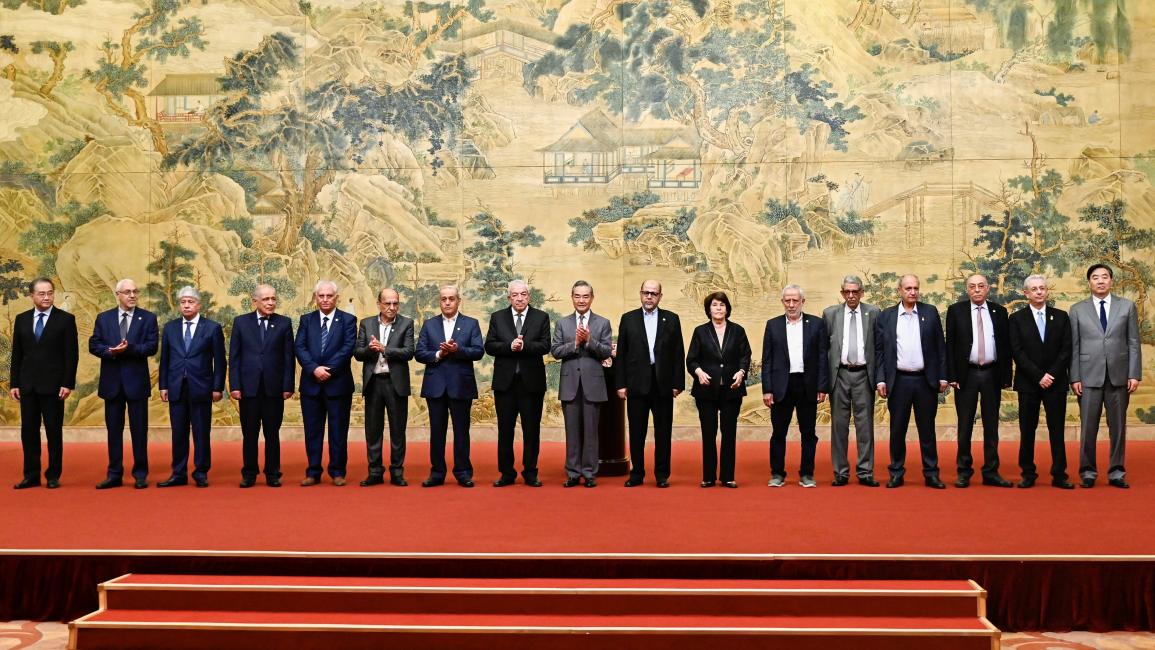 وزير خارجية الصين وأعضاء الفصائل الفلسطينية خلال توقيع "إعلان بكين" (23/7/2024 Getty)