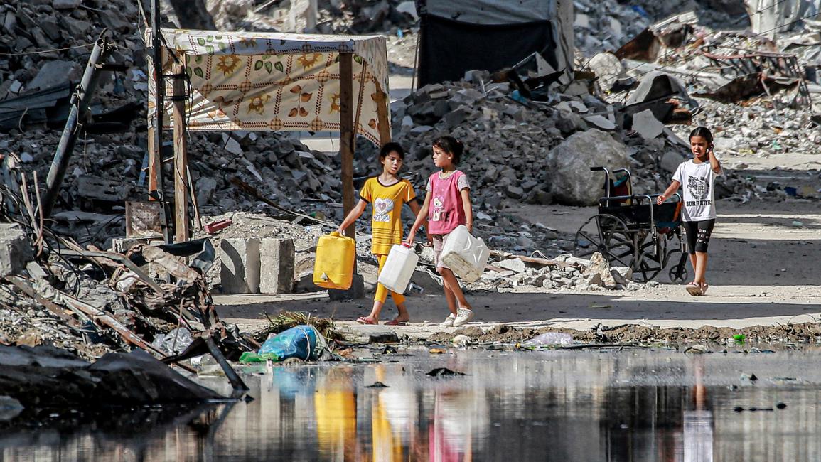 طفلتان تبحثان وسط الركام في خان يونس عن مياه صالح للشرب ( 8/7/2024 فرانس برس) 
