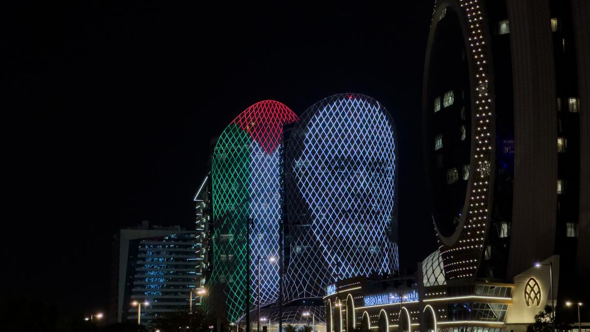 أحد المباني البارزة في الدوحة مضاء بصورة هنية والعلم الفلسطيني (2/8/2024 الأناضول)