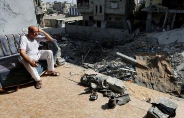 رجل يجلس على شرفة منزل مدمر في قطاع غزة، 15 يونيو 2024 (Getty)