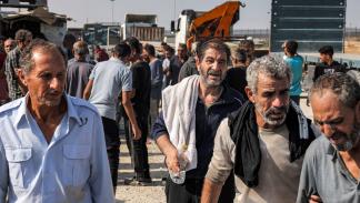 عمال يعودون إلى غزة من معبر كرم أبو سالم يوم 3 نوفمبر 2023 (محمد عابد/فرانس برس)