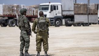 جنديان إسرائيليان قرب شاحنات مساعدات، الأول من مايو الماضي (جاك غويز/فرانس برس)