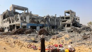 فلسطينية أمام مبنى مدمر لوكالة أونروا غربي مدينة غزة، 12 يوليو 2024 تدمير غزة (عمر القطّاع/فرانس برس)