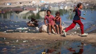 أطفال ومياه صرف صحي في دير البلح وسط قطاع غزة - 23 يوليو 2024 (مجدي فتحي/ Getty)