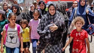نساء وأطفال أثناء إخلاء حي التفاح شرق غزة، 27 يونيو 2024 (فرانس برس)