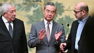 وزير خارجية الصين يتوسط موسى أبو مرزوق (يمين) ومحمود العالول على هامش إعلان بكين / 23 يوليو 2024 (Getty)