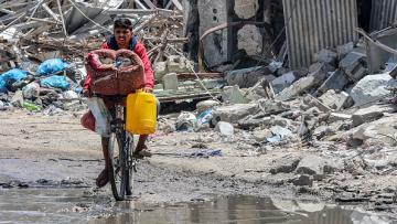 فلسطيني يحمل أغراضه على دراجة هوائية في حي الزيتون وسط قطاع غزة هرباً من القصف الإسرائيلي 9/5/2024 (فرانس برس)