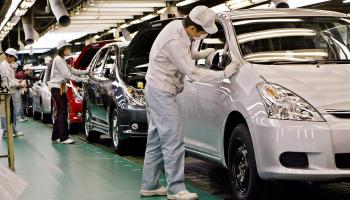 عمال يجمعون سيارات في مصنع تويوتا ياباني (توشيفومي كيتامورا/ فرانس برس)