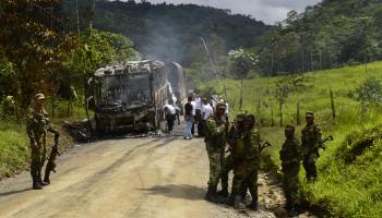 جنود كولومبيون بجوار حافلة هاجمها أفراد من جيش التحرير الوطني قرب توتونيندو تشوكو الكولومبية (Getty)