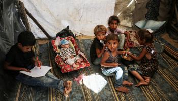 أطفال فلسطينيون داخل خيمة هرباً من أشعة الشمس (مجدي فتحي/Getty)
