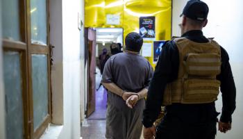 اعتقال متهم بجريمة في البصرة (يونس محمد/ فرانس برس)