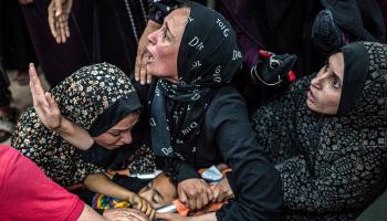 فلسطينيات مفجوعات في غزة حول جثة طفل شهيد - 11 مايو 2024 (فرانس برس)