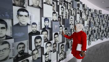 زائرة تركية قرب صور لضحايا 15 يوليو في متحف الديمقراطية في أنقرة (2023/ 7 / 15 الأناضول) 