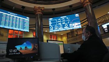 سمسار يتابع أسعار الأسهم على شاشة البورصة المصرية (فاضل داود/Getty)