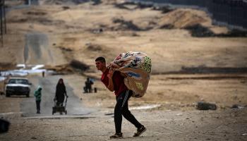 فلسطيني في طريق النزوح من رفح جراء الاجتياح الإسرائيلي، 13 مايو 2024 (Getty)