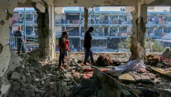 فلسطينيون يتفقدون آثار مجزرة إسرائيلية في إحدى مدارس أونروا بمخيم النصيرات وسط قطاع غزة، 6 يونيو 2024 (Getty)