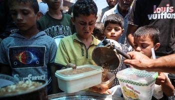 فلسطينيون ينتظرون الحصول على طعام في دير البلح، 10 يونيو (Getty)