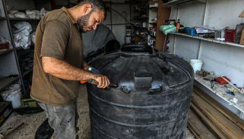 يصلحون خزانات المياه في دير البلح، 13 يونيو 2024 (الأناضول)