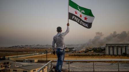 علم المعارضة السورية مكتوب عليه "سوريا الحرة" في تل أبيض، 13 أكتوبر 2019(Getty)
