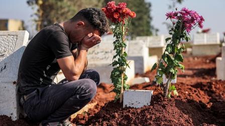 مواطن قرب قبر أحد ضحايا النظام السوري بأعزاز، 23 نوفمبر 2022 (فرانس برس)