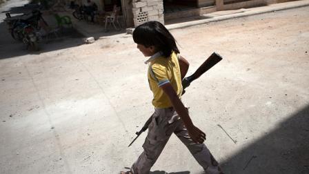 صبي سوري يمشي حاملاً بندقية بمعرة النعمان، 13 يونيو 2013 (فرانس برس)