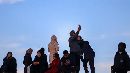 فلسطيني يحاول التقاط إشارة شبكة الاتصالات في رفح، 19 يناير 2024 (فرانس برس)