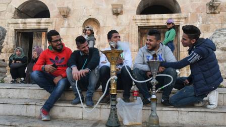 يدخنون النراجيل في مدينة عمان القديمة (خليل مزرعاوي/ فرانس برس)