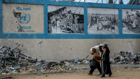 فلسطينيون والمقر الرئيسي لوكالة أونروا في قطاع غزة وسط الحرب (فرانس برس)