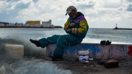صياد يجهز شبكة الصيد في ميناء على الساحل الجنوبي لتونس، 7 يناير 2023 (Getty)