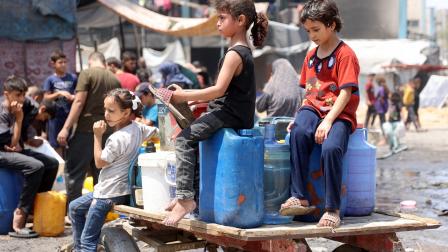 يشارك الأطفال في غزة في تأمين المياه بشكل يومي (عمر القطا/ فرانس برس)
