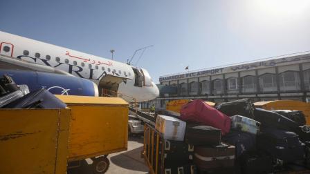 إنزال الحقائب من طائرة تابعة للخطوط السورية في مطار دمشق طيران سورية (لؤي بشارة/فرانس برس)