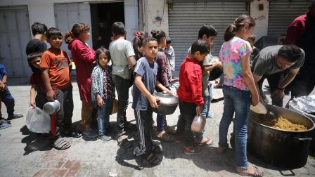 أطفال فلسطينيون ينتظرون وجبة غذاء في مدينة غزة - 14 مايو 2024 (داود أبو الكاس/ الأناضول)